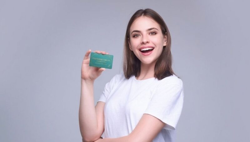 Devojka drži vizit kartu koja izgleda kvalitetno i moderno izrađena