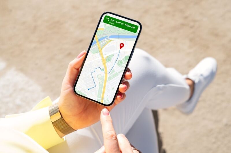 Osoba koristi telefon sa mapom i navigacijom kako bi pronašla lokal u blizini